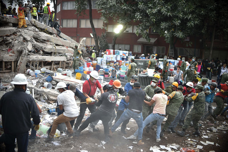Real Estate,Una cadena humana trabaja para remover los escombros de un edificio de la capital.